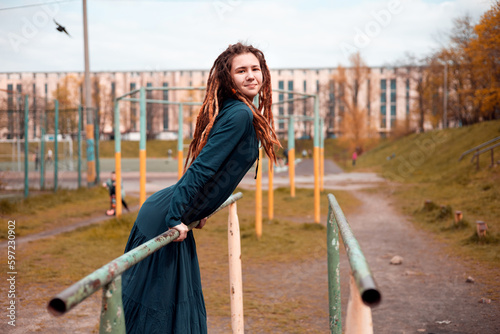 beautiful girl hipster with dreadlocks outdoors wearing trendy green long dress.