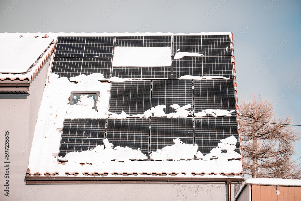panele słoneczne na dachu, a na nich rozpuszczający się śnieg - obrazy, fototapety, plakaty 