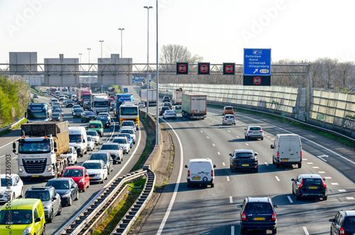 Rotterdam, The Netherlands, April 5, 2023: view from a viaduct over the A20 highway, with a traffic jam in one direction and busy traffic in the other