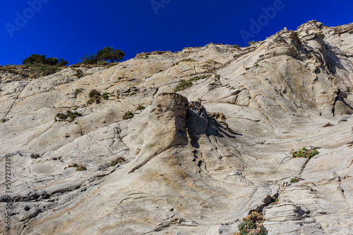 unusual rock formations of the volcanic cliff on Cala Sapone beach, quartz-trachitic ignimbrites. photo