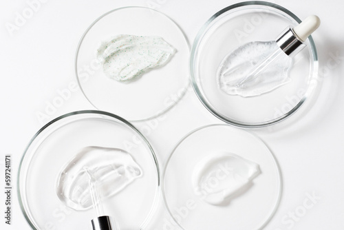 Drops and smears of cosmetics, pipette and petri dish. Drops of liquid transparent gel with bubbles on a white background. Cosmetic background.