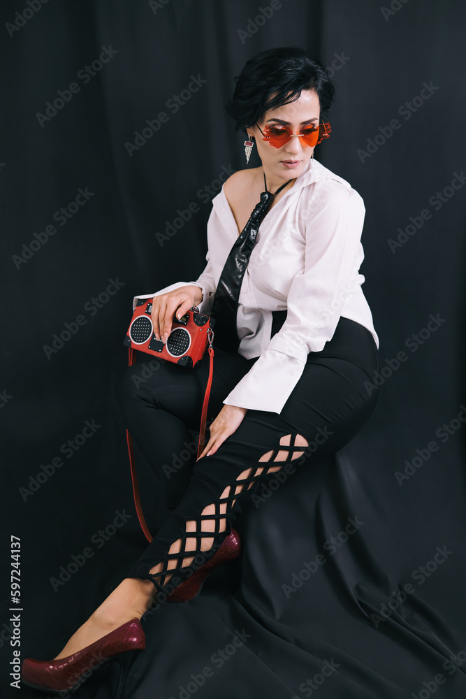 Stylish shot of young lady in white shirt posing for camera in studio