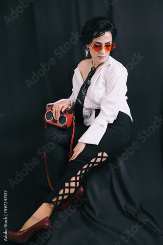 Obraz na płótnie Stylish shot of young lady in white shirt posing for camera in studio w salonie