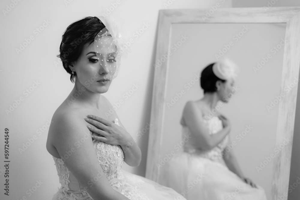 Medium shot of elegant bride in front of the mirror waiting for the groom