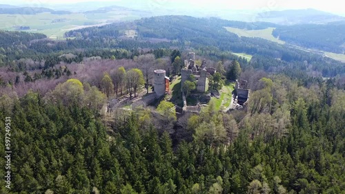 Aerial shot of the castle in the middle of the woods. A ruined castle located on a hill in the middle of the woods. Medieval castle tower