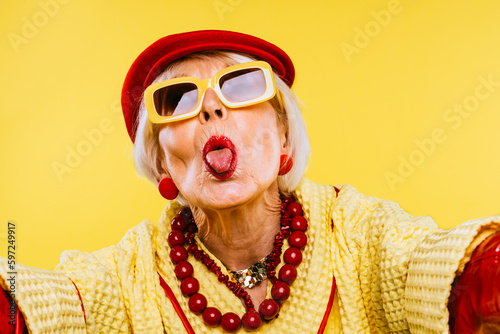 Cool and stylish senior old woman with fashionable clothes - Elderly funny female with stylish colorful dress portrait on isolated colored background
