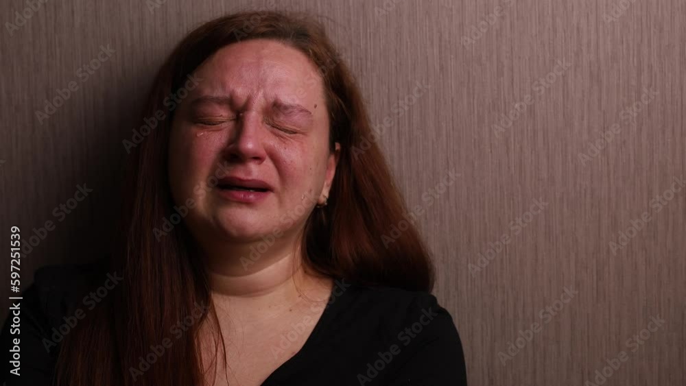 Distressed woman bitterly cry near room wall. Tears roll down cheeks, tearful eyes and swollen face. Splash out emotions, sob violently. Emotional breakdown, sufferings. Depression and hysterics. Distressed woman bitterly cry near room wall. Tears roll down cheeks, tearful eyes and swollen face. Splash out emotions, sob violently. Emotional breakdown, sufferings. Depression and hysterics.