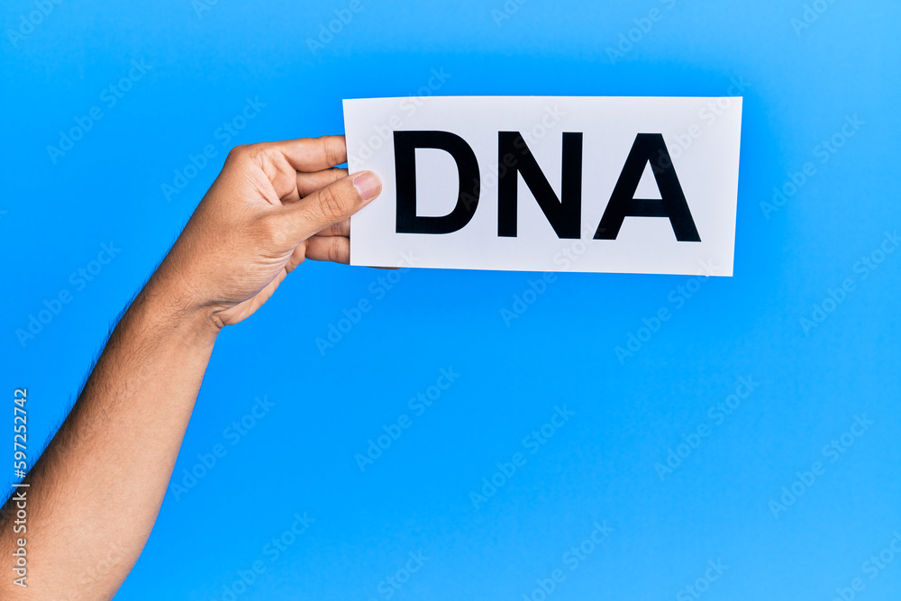 Hand of caucasian man holding paper with dna word over isolated white background Hand of caucasian man holding paper with dna word over isolated white background
