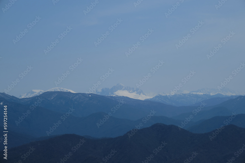 Minimalistic landscape , no people. View of snowy peak of Mount Fisht from afar. Main Caucasian ridge in reserve. Beautiful views of nature of Russia. Oshten and Psheho Su.