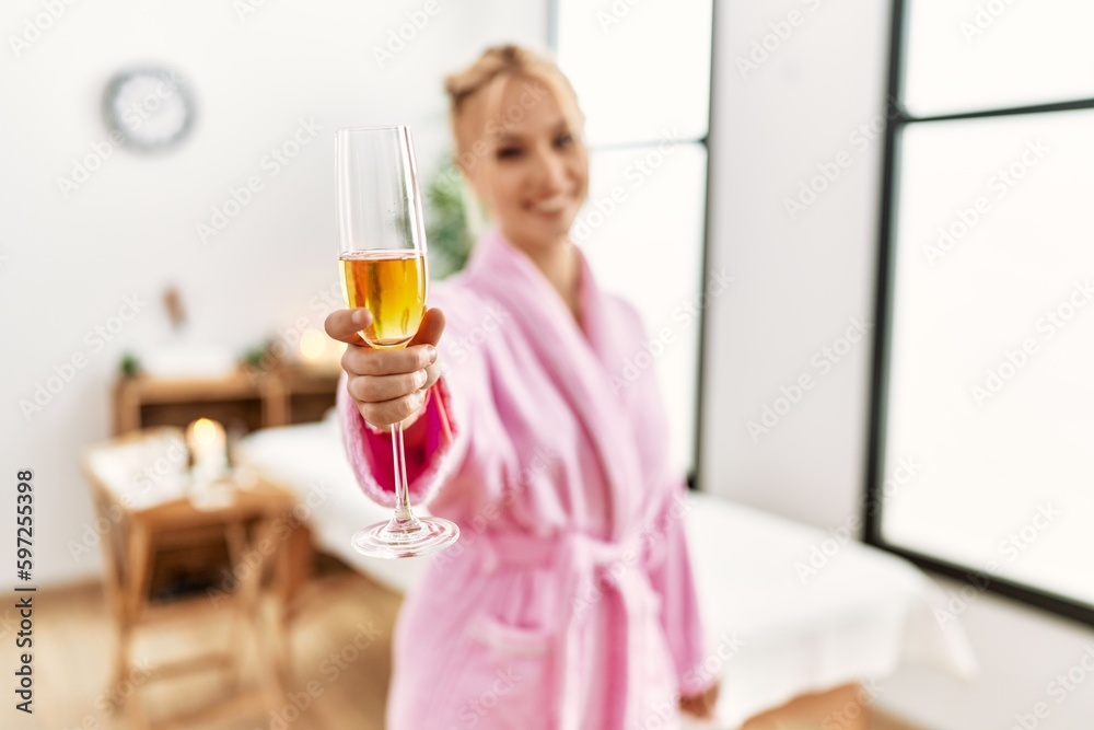 Young caucasian woman wearing bathrobe drinking champagne at beauty salon Young caucasian woman wearing bathrobe drinking champagne at beauty salon