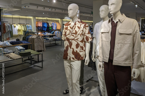 Empty men clothing store inside schopping center. Modern fashionable brand clothing store with mannequins, clothes racks and hangers