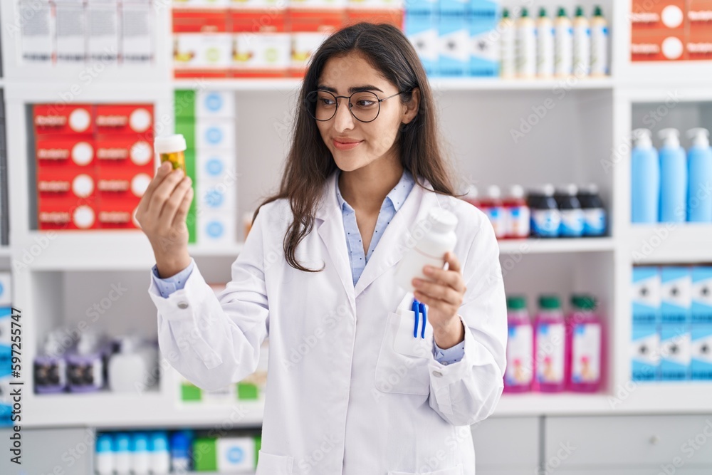Young hispanic girl pharmacist choosing pills at pharmacy Young hispanic girl pharmacist choosing pills at pharmacy