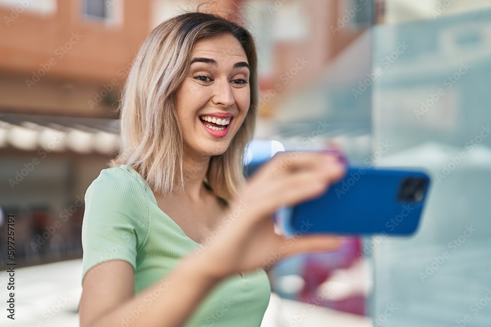 Young woman smiling confident watching video on smartphone at street Young woman smiling confident watching video on smartphone at street