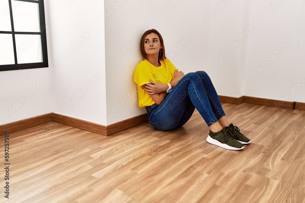 Young woman unhappy sitting on floor at empty room Young woman unhappy sitting on floor at empty room