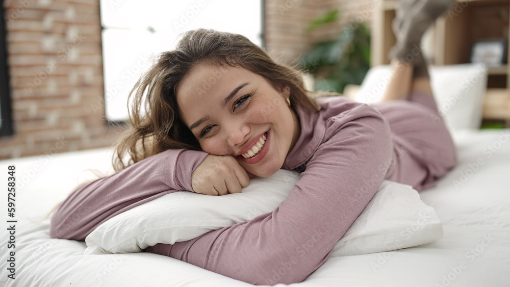Young beautiful hispanic woman hugging pillow lying on bed at bedroom Young beautiful hispanic woman hugging pillow lying on bed at bedroom