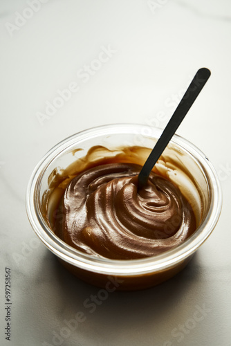 Salted Caramel sauce in glass bowl on white marble background. Butter, sugar with cream and salt. 