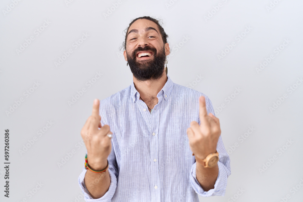 Hispanic man with beard wearing casual shirt showing middle finger doing fuck you bad expression, provocation and rude attitude. screaming excited Hispanic man with beard wearing casual shirt showing middle finger doing fuck you bad expression, provocation and rude attitude. screaming excited