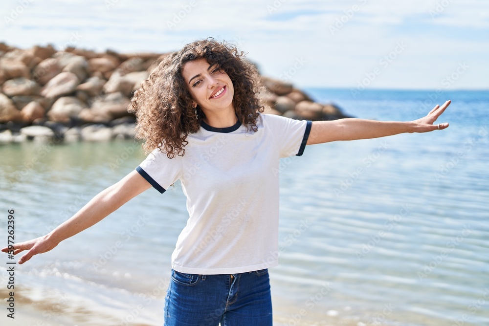 Young hispanic woman smiling confident standing with arms open at seaside Young hispanic woman smiling confident standing with arms open at seaside