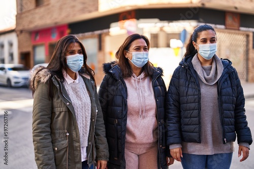 Three woman mother and daughters wearing medical mask standing together at street © Krakenimages.com