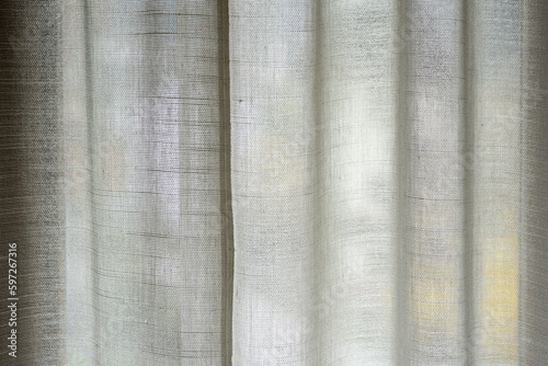 una bella tenda d'appartamento di colore bianco chiude una finestra