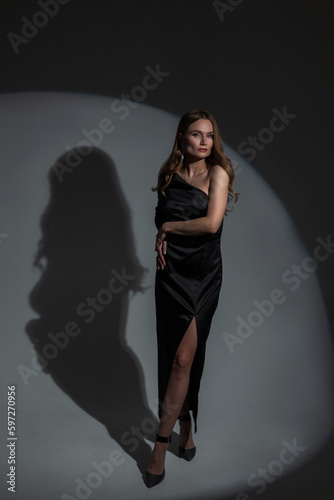 Elegant beautiful festive girl model in a fashionable evening black dress at a party. Pretty woman celebration