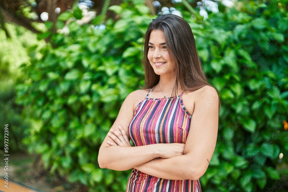 Young beautiful hispanic woman standing with arms crossed gesture at park Young beautiful hispanic woman standing with arms crossed gesture at park