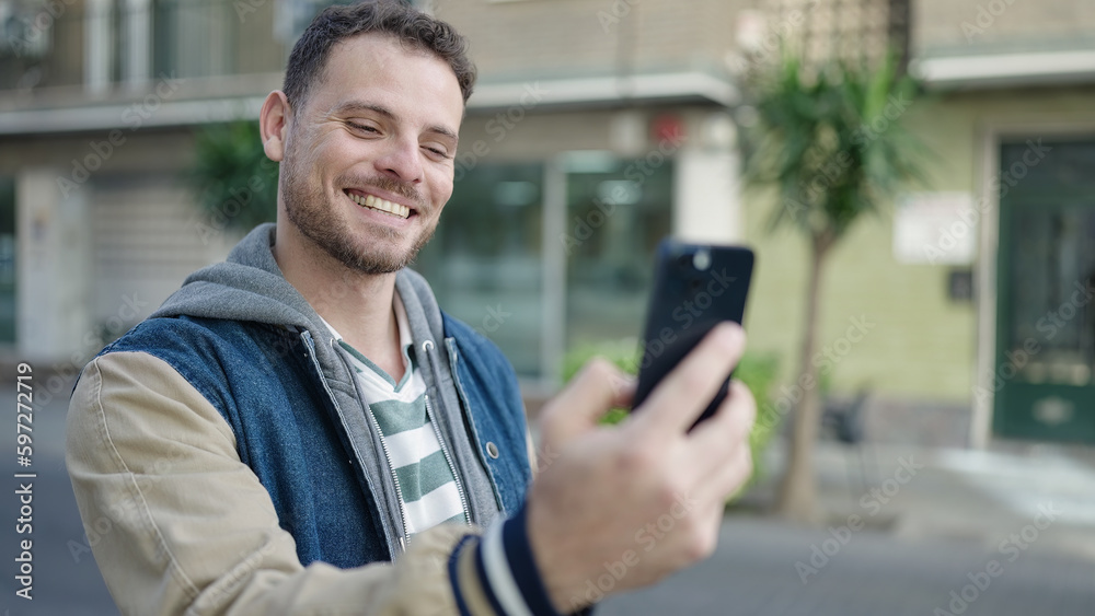 Young caucasian man smiling on a video call at street Young caucasian man smiling on a video call at street