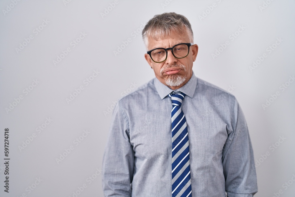 Hispanic business man with grey hair wearing glasses looking sleepy and tired, exhausted for fatigue and hangover, lazy eyes in the morning.