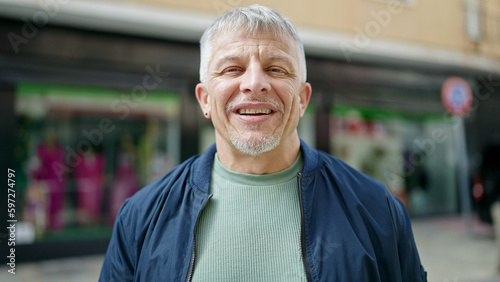 Middle age grey-haired man smiling confident standing at street