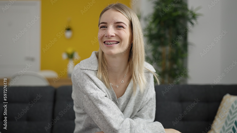 Young blonde woman smiling confident sitting on the sofa at home Young blonde woman smiling confident sitting on the sofa at home