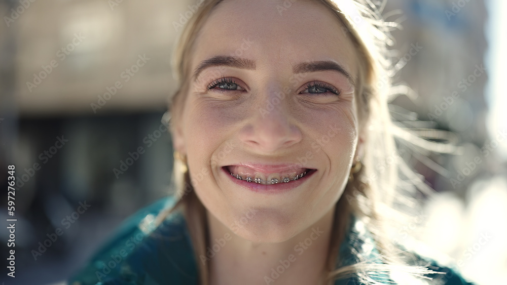 Young blonde woman smiling confident showing braces at street Young blonde woman smiling confident showing braces at street