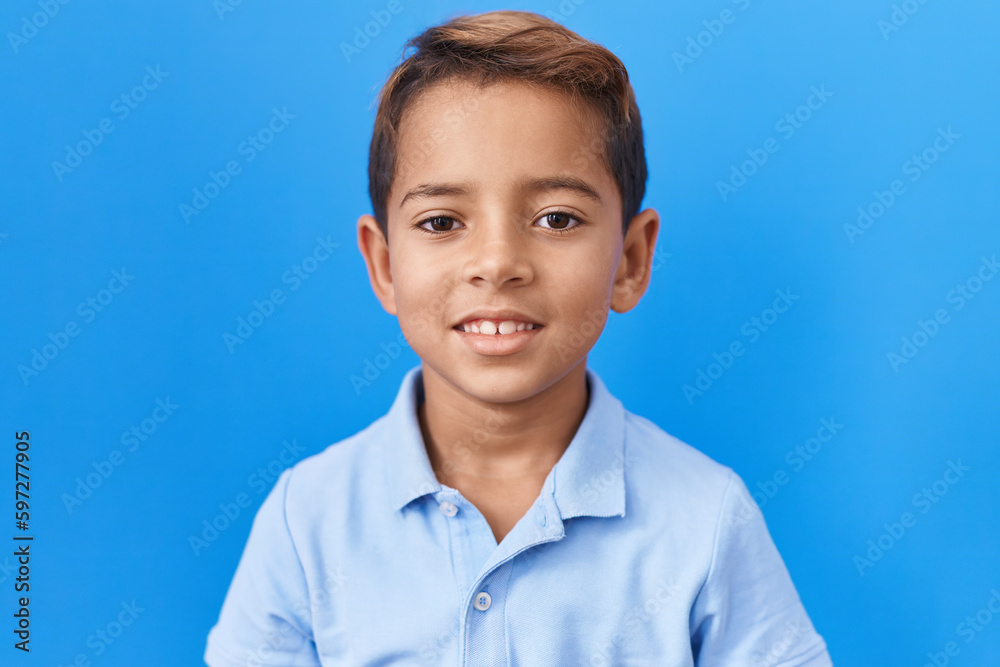 Little hispanic boy wearing casual blue t shirt with a happy and cool smile on face. lucky person. Little hispanic boy wearing casual blue t shirt with a happy and cool smile on face. lucky person.