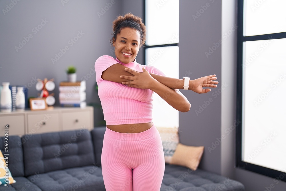 African american woman smiling confident stretching arm at home