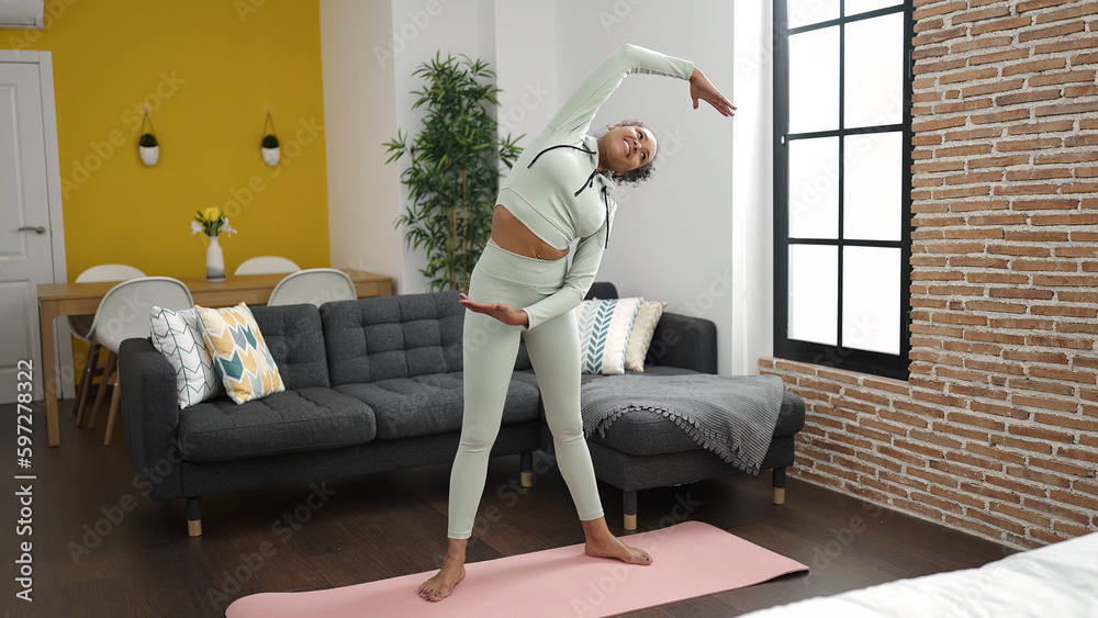 African american woman smiling confident stretching at home