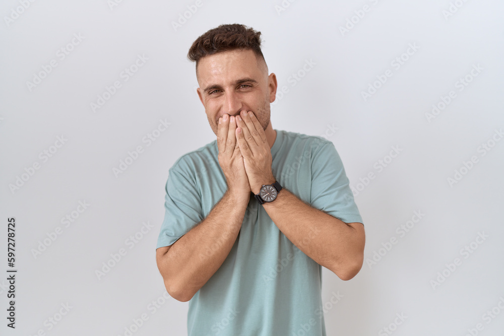Hispanic man with beard standing over white background laughing and embarrassed giggle covering mouth with hands, gossip and scandal concept Hispanic man with beard standing over white background laughing and embarrassed giggle covering mouth with hands, gossip and scandal concept