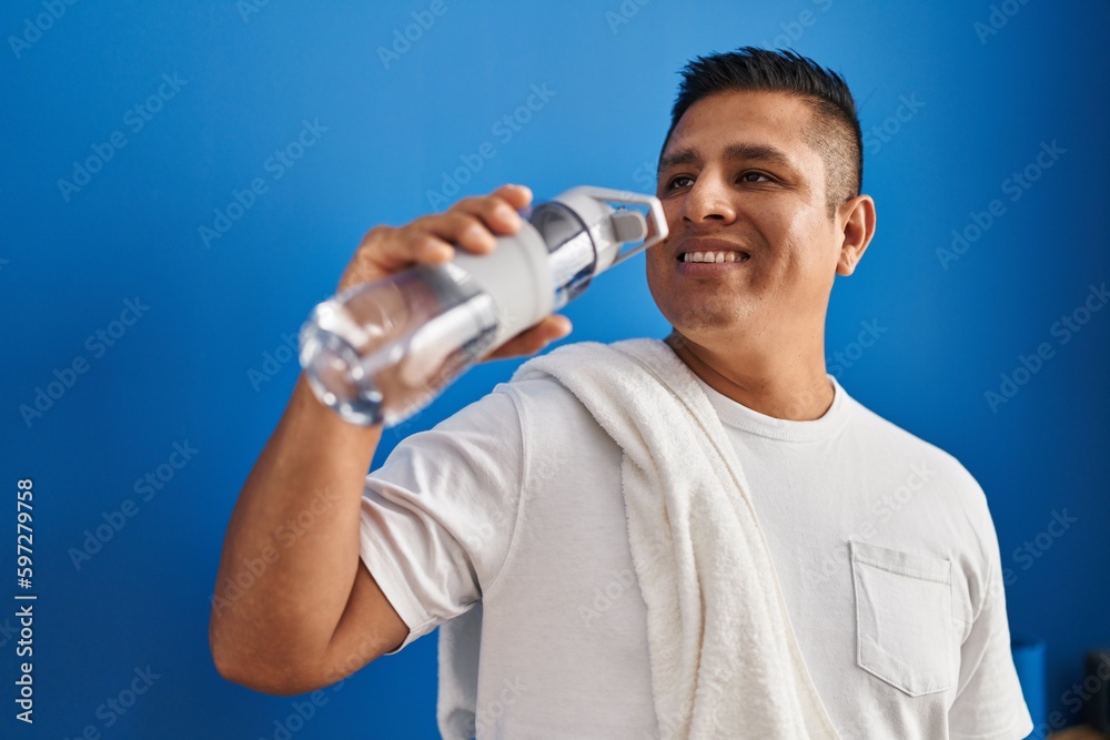 Young latin man smiling confident drinking water at sport center Young latin man smiling confident drinking water at sport center
