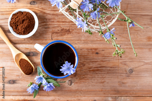 Healthy chicory drink in cup decorated chicory flowers on a table. Herbal beverage, coffee substitute. Close up. Copy space.