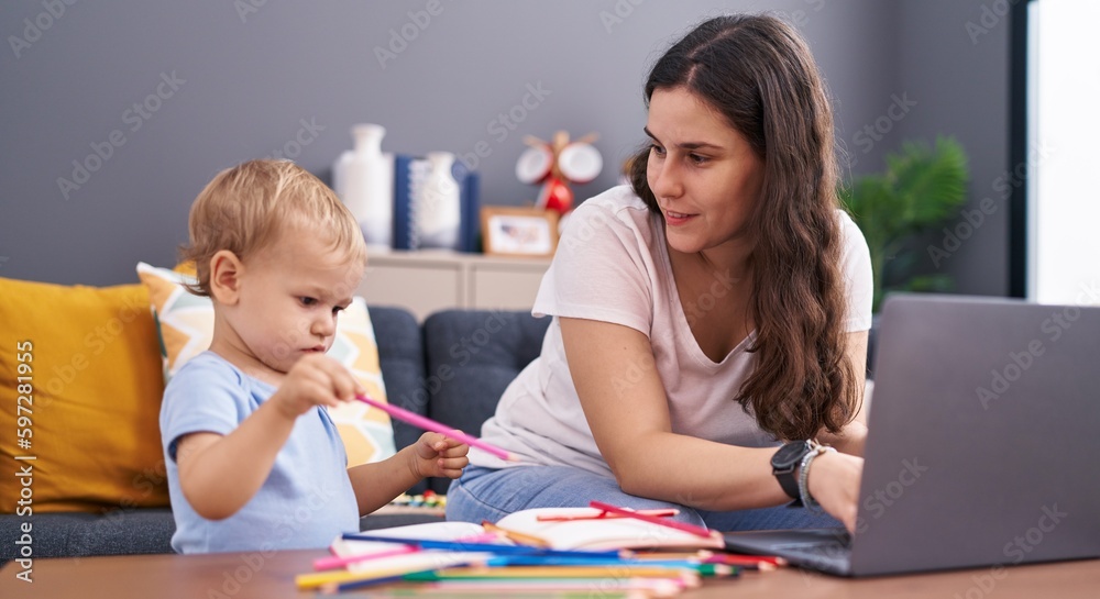 Mother and son drawing on notebook using laptop at home Mother and son drawing on notebook using laptop at home