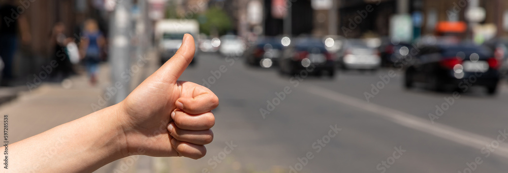 Male hand in a gesture of hitchhiking Male hand in a gesture of hitchhiking
