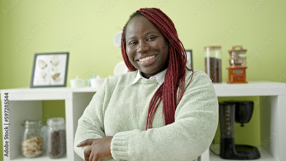 African woman with braided hair smiling confident with crossed arms at dinning room African woman with braided hair smiling confident with crossed arms at dinning room