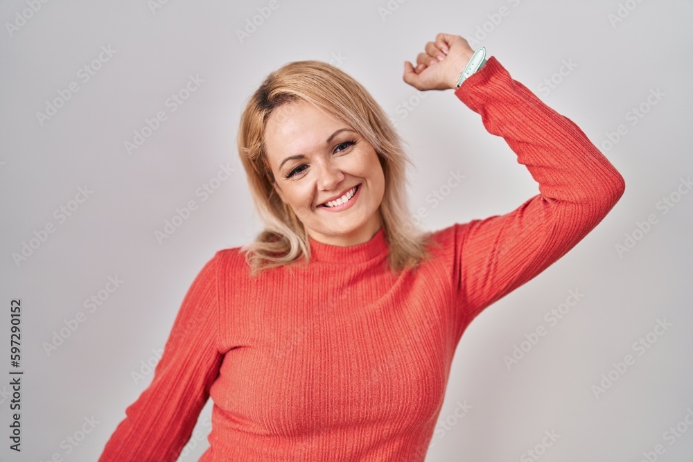 Blonde woman standing over isolated background dancing happy and cheerful, smiling moving casual and confident listening to music Blonde woman standing over isolated background dancing happy and cheerful, smiling moving casual and confident listening to music