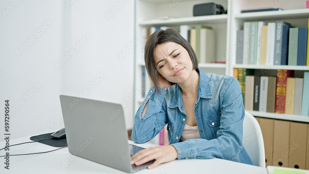 Young caucasian woman student using laptop stressed at university classroom Young caucasian woman student using laptop stressed at university classroom
