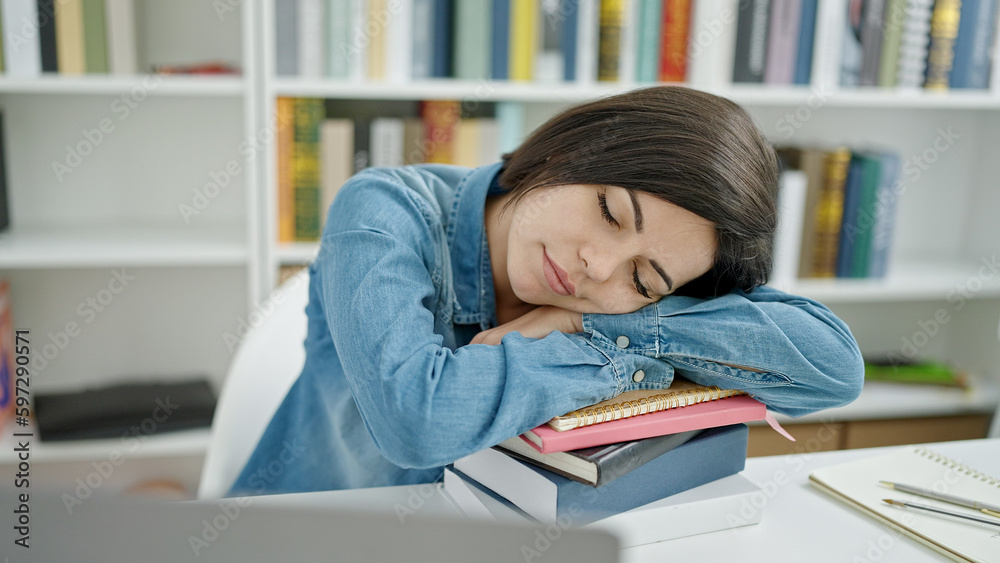 Young caucasian woman student sleeping with head on books at university classroom Young caucasian woman student sleeping with head on books at university classroom
