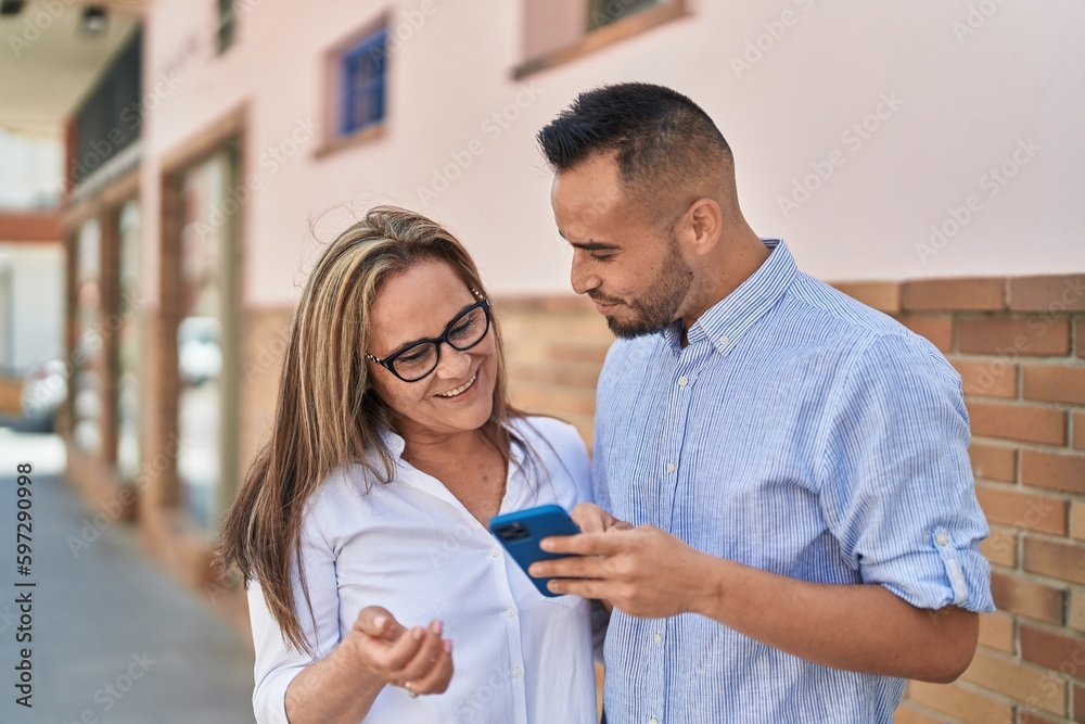 Fototapeta premium Man and woman mother and daugther using smartphone at street