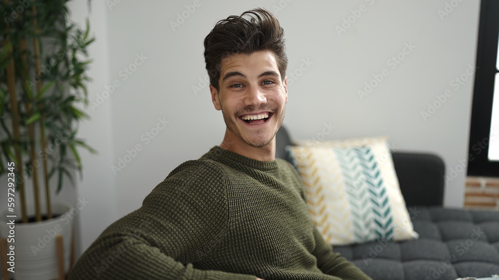 Young hispanic man smiling confident sitting on sofa at home Young hispanic man smiling confident sitting on sofa at home