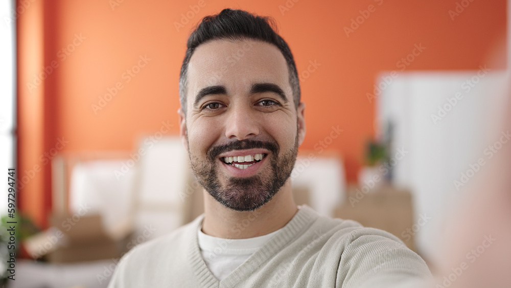 Young hispanic man having video call standing at new home Young hispanic man having video call standing at new home