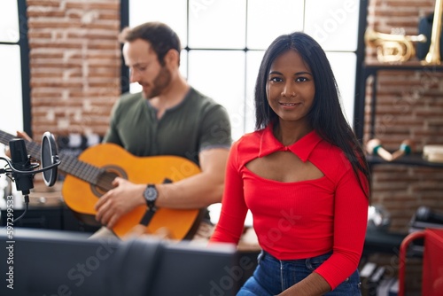 Man and woman musicians playing classical guitar and piano at music studio