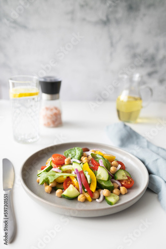 Vegetarian salad with chickpeas and fresh vegetables, cherry tomatoes, cucumber, paprika and lettuce. Ideal for lunch and dinner. Plant foods rich in protein. © Elena Medoks