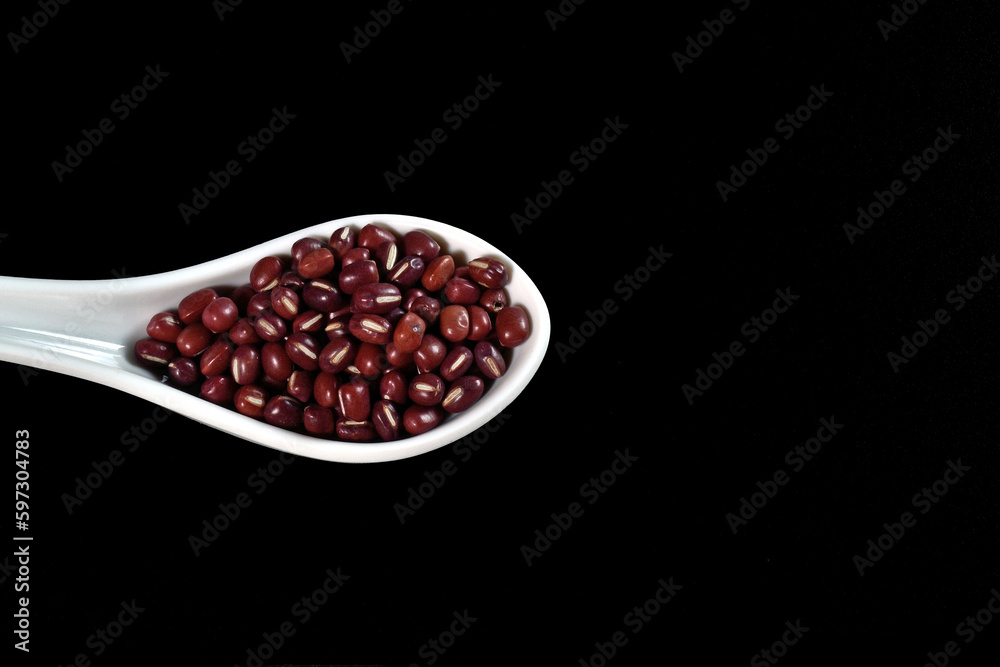 White ceramic spoon filled with red soy isolated on black background. White ceramic spoon filled with red soy isolated on black background.