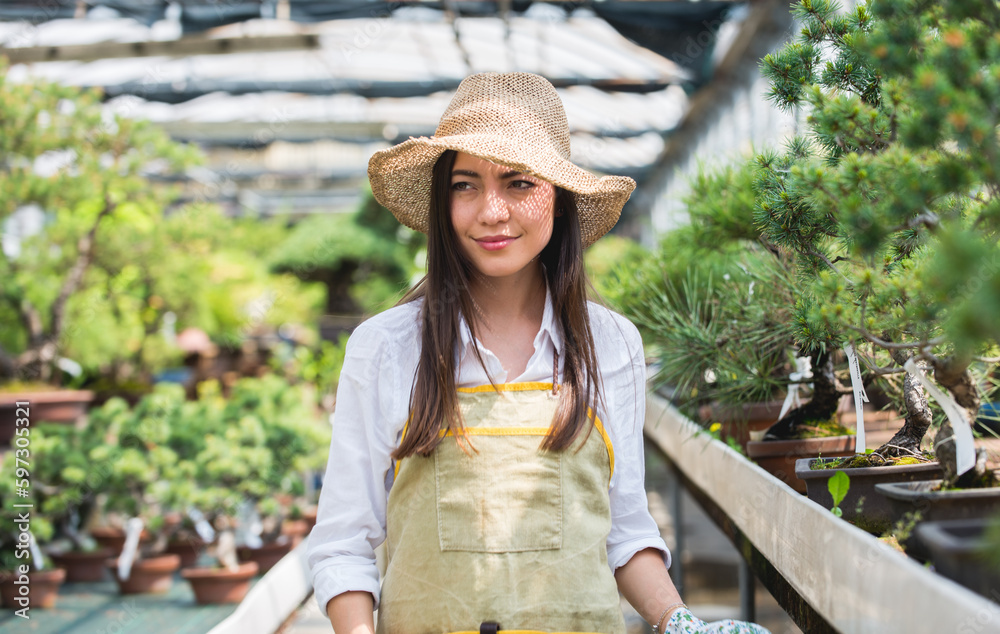 Obraz premium Beautiful woman working in a greenhouse